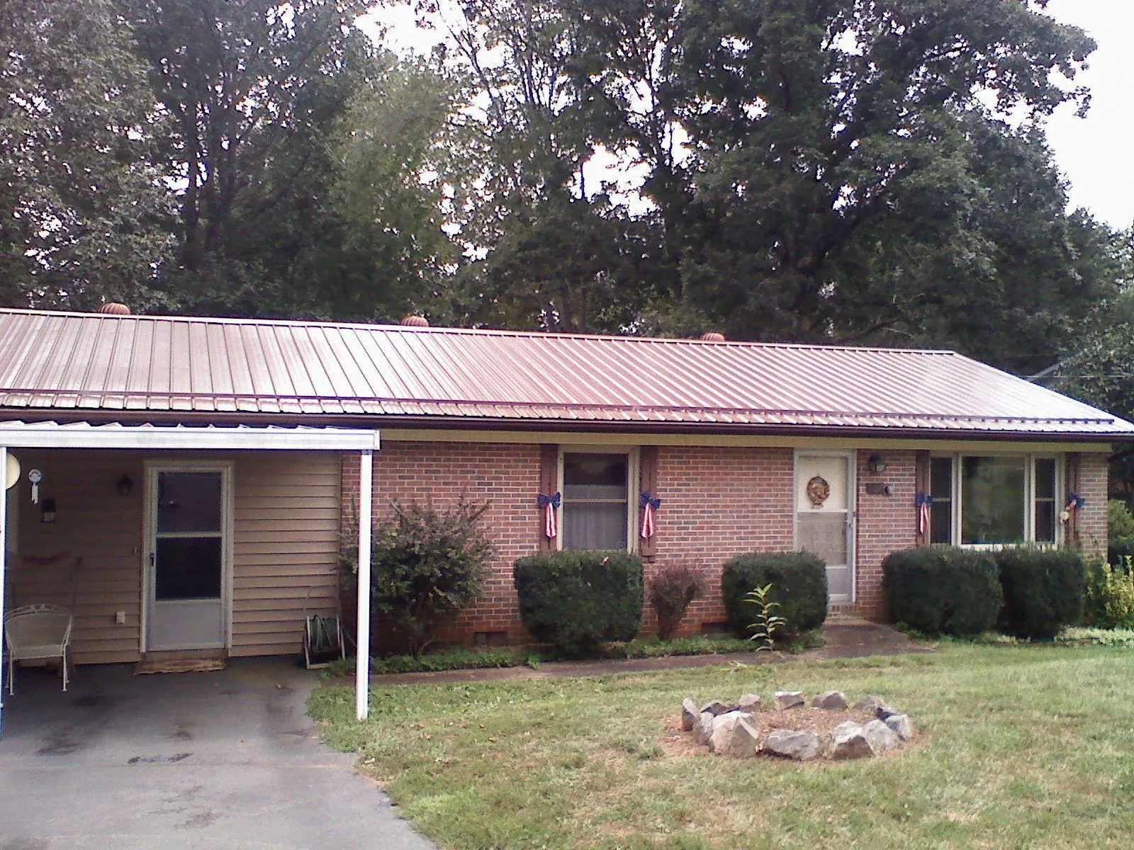 Bronze metal roof and carport on a brick ranch home — Roof Repair work by our crew in Drake
